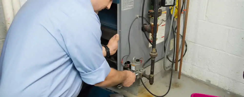 Furnace repair technician inspecting and servicing a home heating system in Pittsburgh, PA