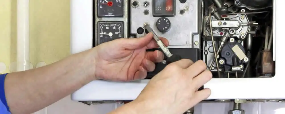 Heating repair technician adjusting boiler controls and components in Pittsburgh, PA