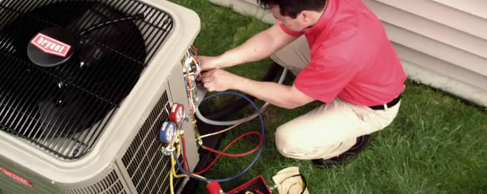 HVAC technician servicing an outdoor air conditioner unit in Pittsburgh, PA