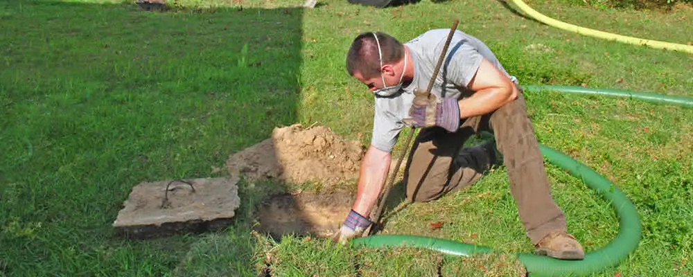 Septic pumping technician servicing a residential septic tank in Pittsburgh, PA