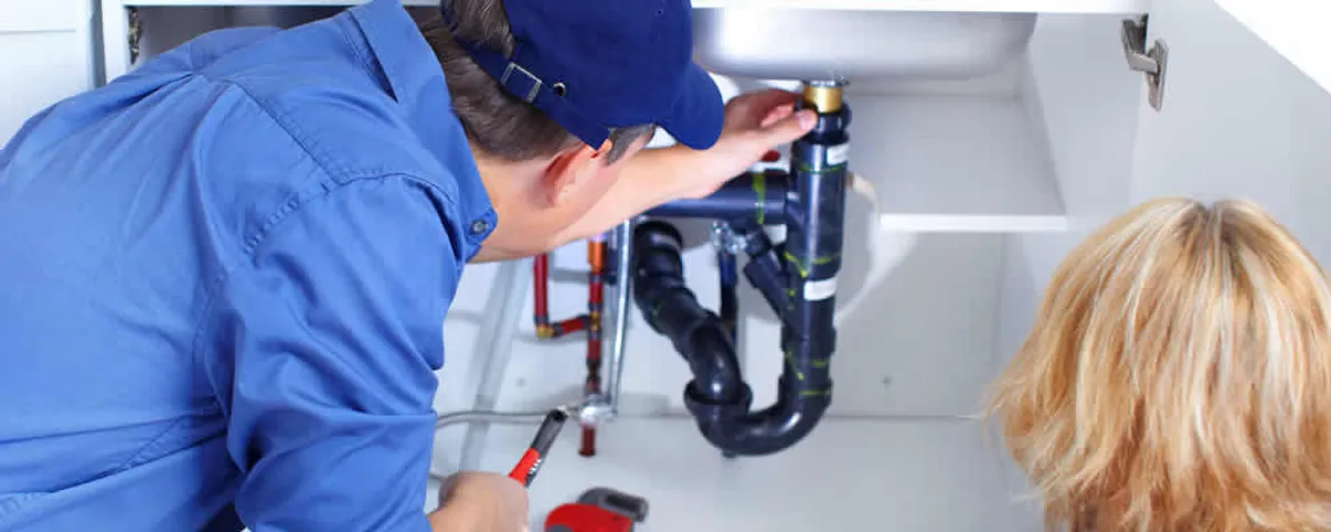 Plumber repairing under-sink drain pipes and fittings in Pittsburgh, PA